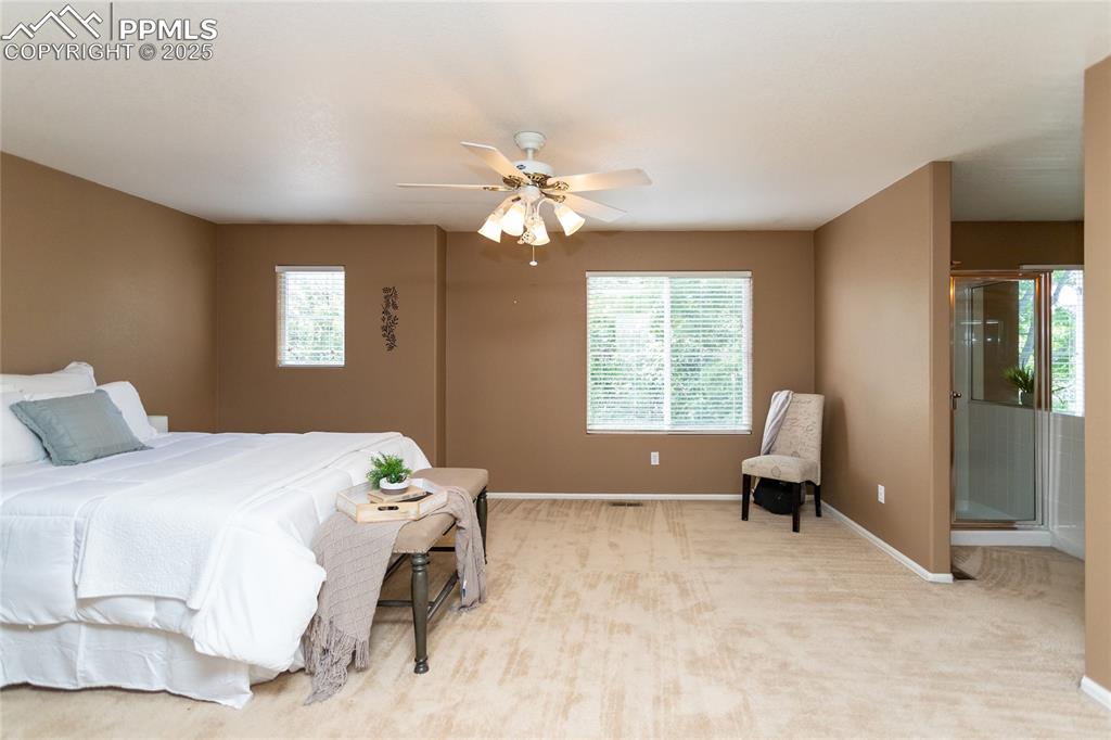 6815 Anchor Point Colorado Springs, CO 80922 - Photo 22 of 46 a bedroom with a bed and a chandelier