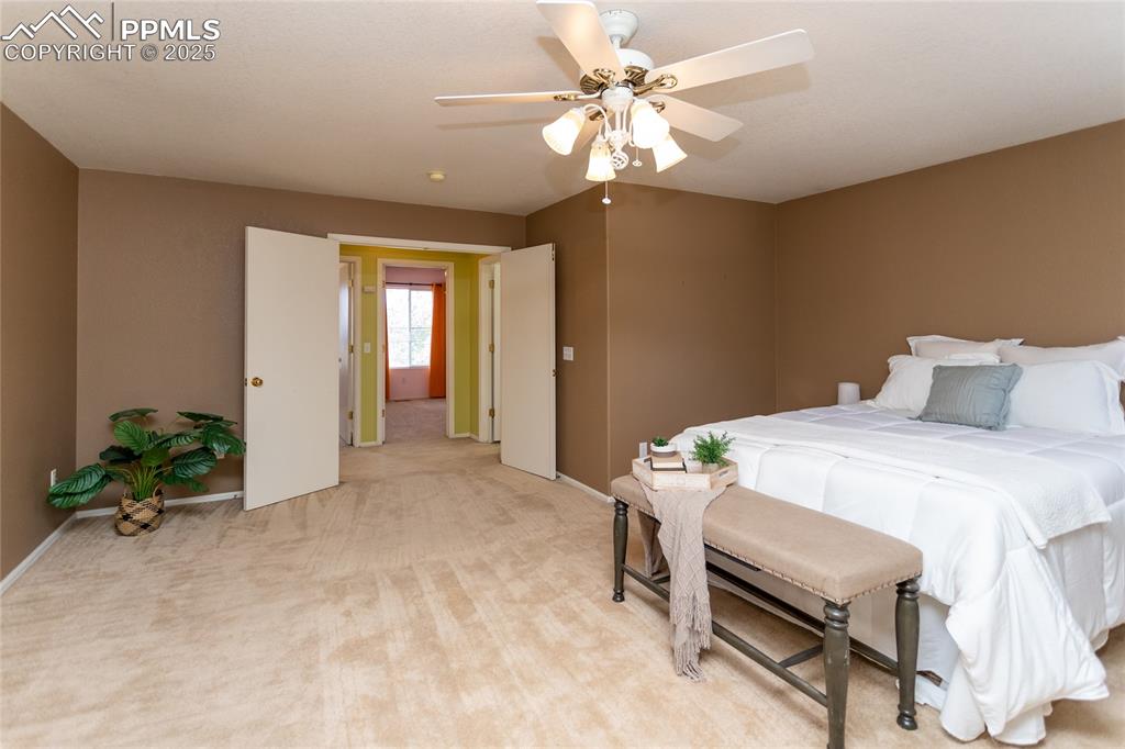 6815 Anchor Point Colorado Springs, CO 80922 - Photo 23 of 46 a bedroom with a bed and a chandelier