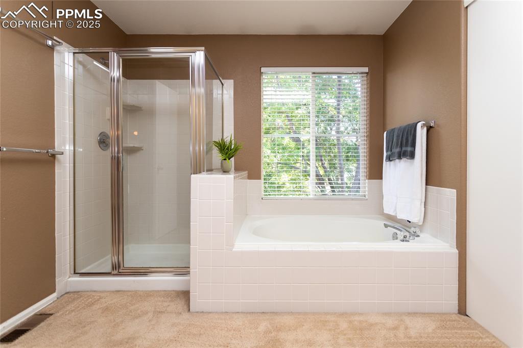 6815 Anchor Point Colorado Springs, CO 80922 - Photo 27 of 46 a bathroom with a bathtub and shower
