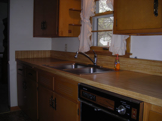 1621 Warren Road Rockford, IL 61108 - Photo 6 of 11 a kitchen with a sink and a stove with cabinets