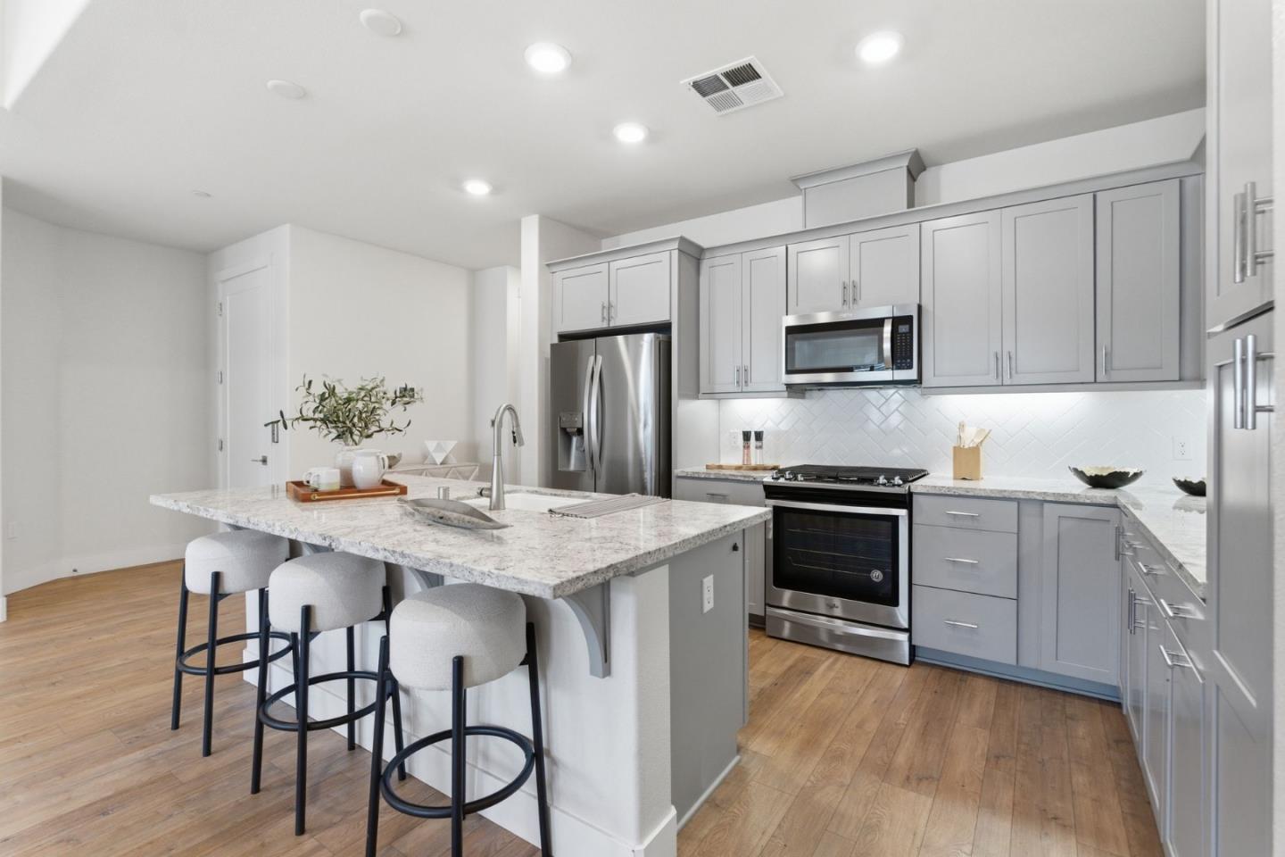 195 Carson Falls Common Fremont, CA 94539 - Photo 15 of 52 a kitchen with stainless steel appliances granite countertop a stove refrigerator sink and cabinets