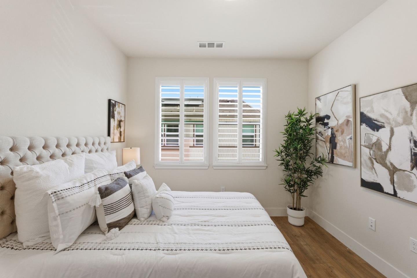 195 Carson Falls Common Fremont, CA 94539 - Photo 39 of 52 a spacious bedroom with a large bed and a potted plant