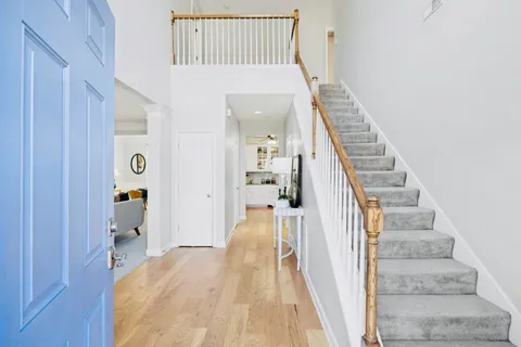 a view of a hallway with wooden floor and staircase