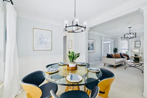 a view of a dining room with furniture a chandelier and wooden floor