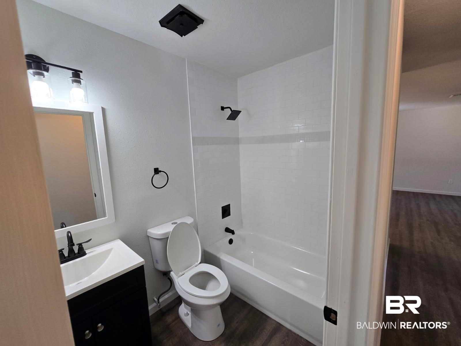 1404 Dailey Street Brewton, AL 36426 - Photo 18 of 25 Bathroom featuring dark wood-style flooring, vanity, and shower / bathtub combination