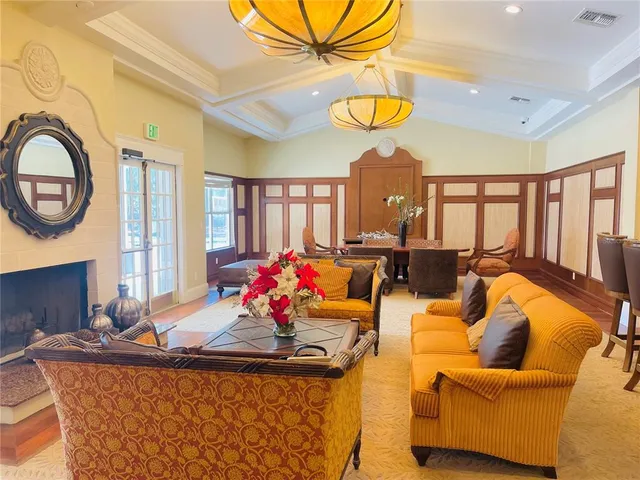 a room with furniture pool table and large windows