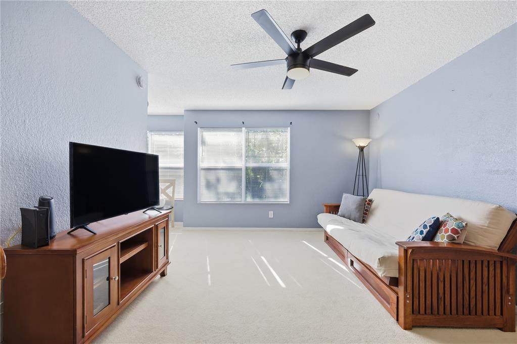 5108 Conroy Road, Unit 1724 Orlando, FL 32811 - Photo 17 of 40 a living room with furniture and a flat screen tv