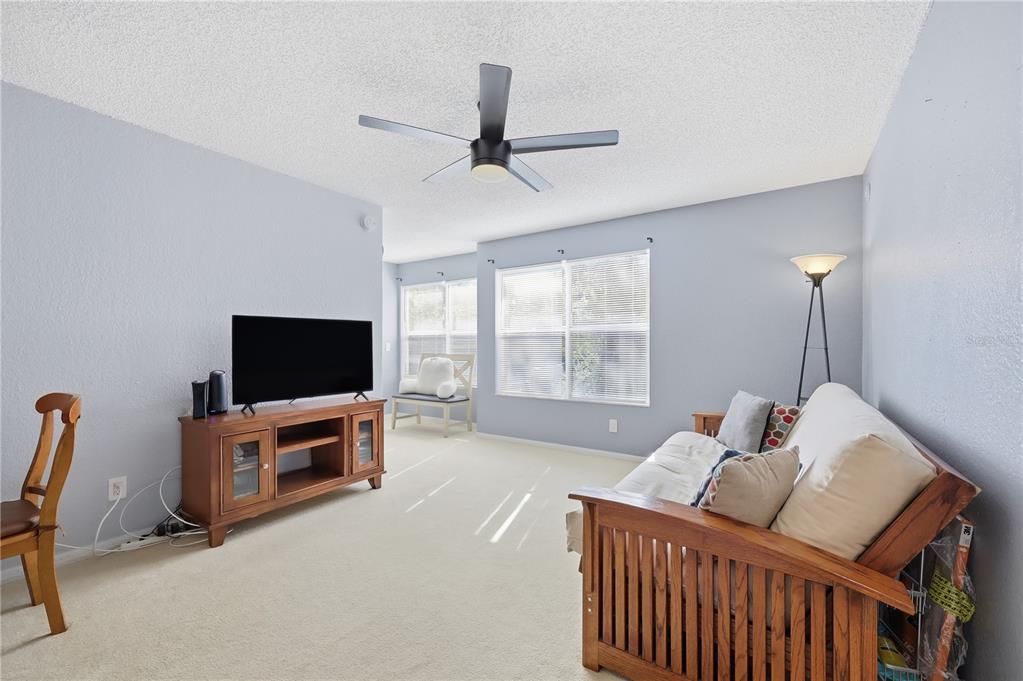 5108 Conroy Road, Unit 1724 Orlando, FL 32811 - Photo 18 of 40 a living room with furniture and a flat screen tv