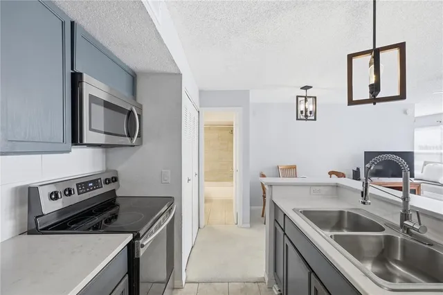 a kitchen with stainless steel appliances a refrigerator sink and microwave