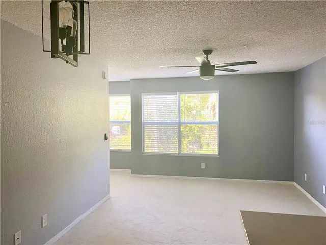 an empty room with windows and cabinet