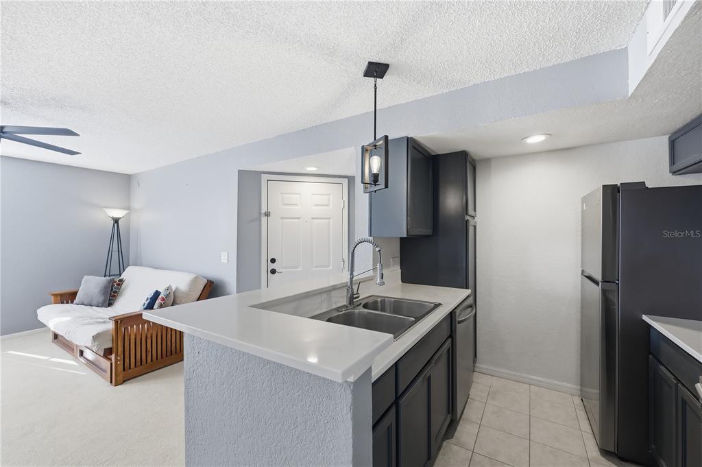 5108 Conroy Road, Unit 1724 Orlando, FL 32811 - Photo 10 of 40 a kitchen with stainless steel appliances granite countertop a sink and a refrigerator