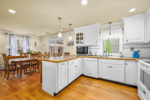 a large white kitchen with cabinets a sink and a stove