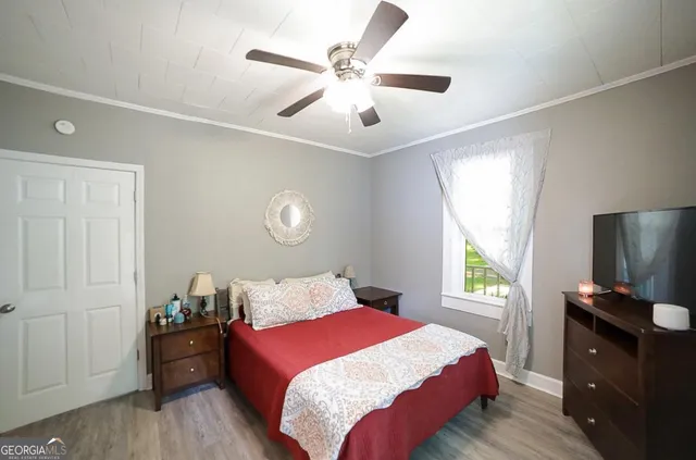 a bedroom with a bed and a flat tv screen on dresser