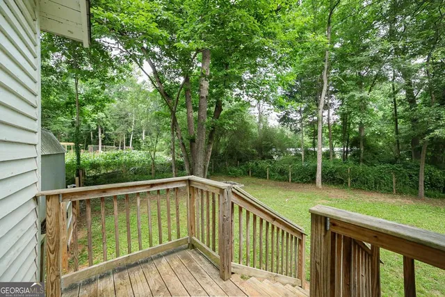 a view of deck with trees and wooden fence