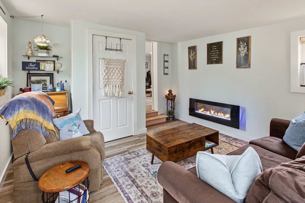 1668 Vandervort Hill Road Unadilla, NY 13849 - Photo 37 of 50 A modern wall-mounted fireplace adds architectural interest to this cozy living space with wood flooring.