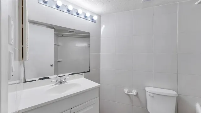 a bathroom with a sink toilet and mirror