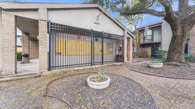 a backyard of a house with fountain table and chairs