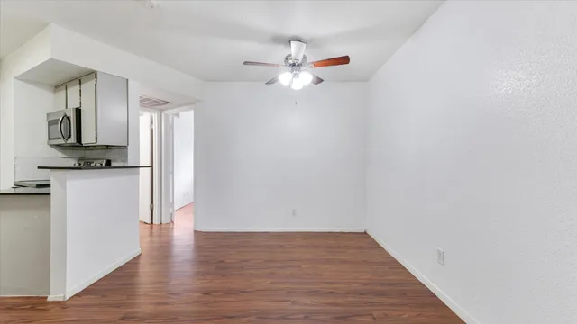 a view of empty room with wooden floor