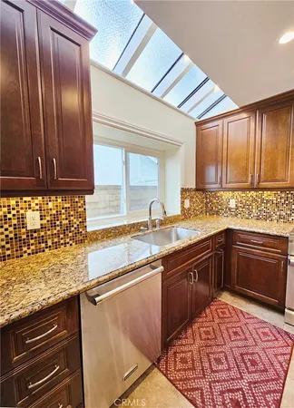a kitchen with kitchen island a dining table chairs stainless steel appliances and cabinets