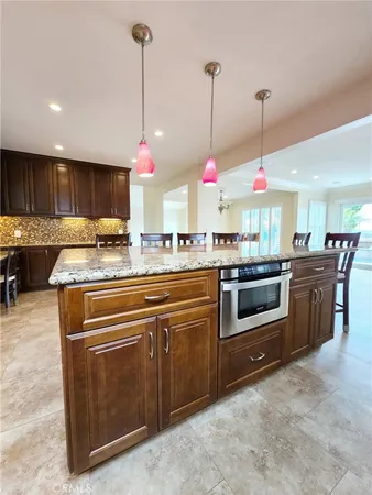 a kitchen with stainless steel appliances granite countertop a refrigerator a sink and a stove