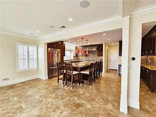 a dining hall with stainless steel appliances a dining table and chairs