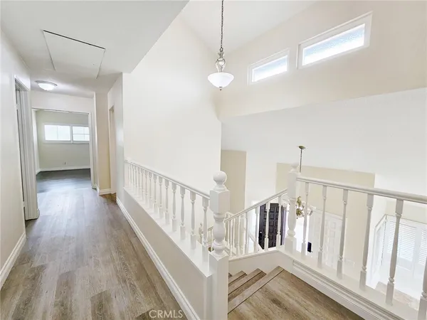 an empty room with wooden floor cabinet and windows