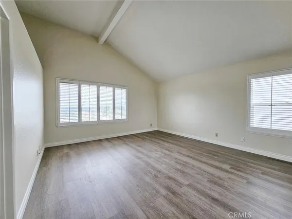 an empty room with wooden floor and white walls