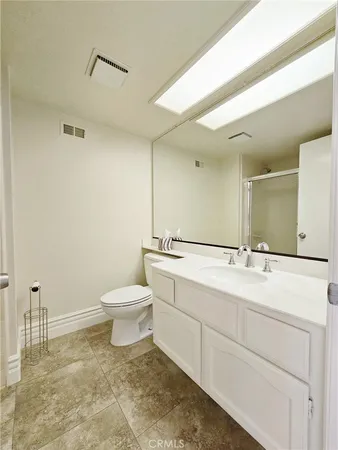 an empty room with chandelier fan and windows