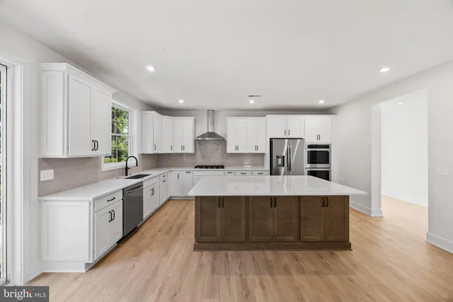 a kitchen with kitchen island granite countertop a sink appliances cabinets and counter space