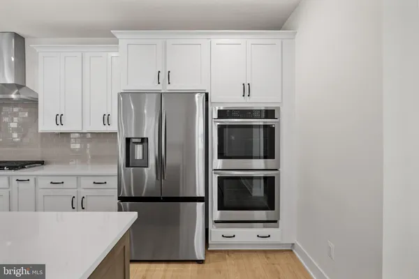 a kitchen with granite countertop white cabinets and white appliances