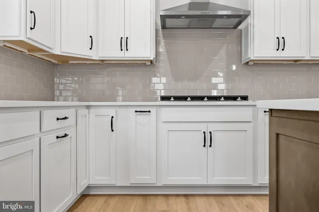 a kitchen with a stove a sink dishwasher and a refrigerator with wooden floor