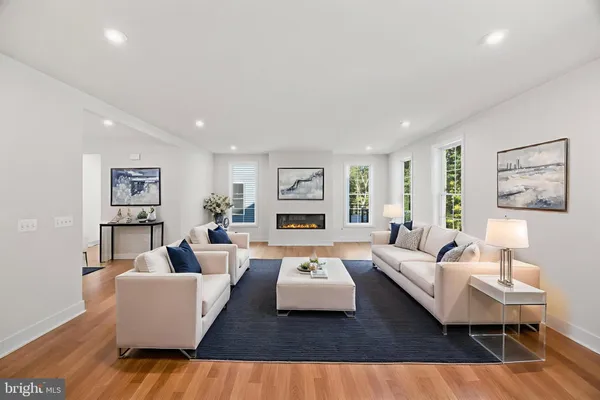 an empty room with wooden floor fireplace and windows