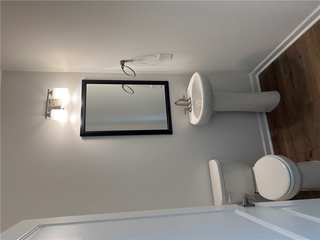 211 Bellflower Lane Anderson, SC 29625 - Photo 7 of 28 A well-appointed lavatory with a pedestal sink and modern lighting fixtures.