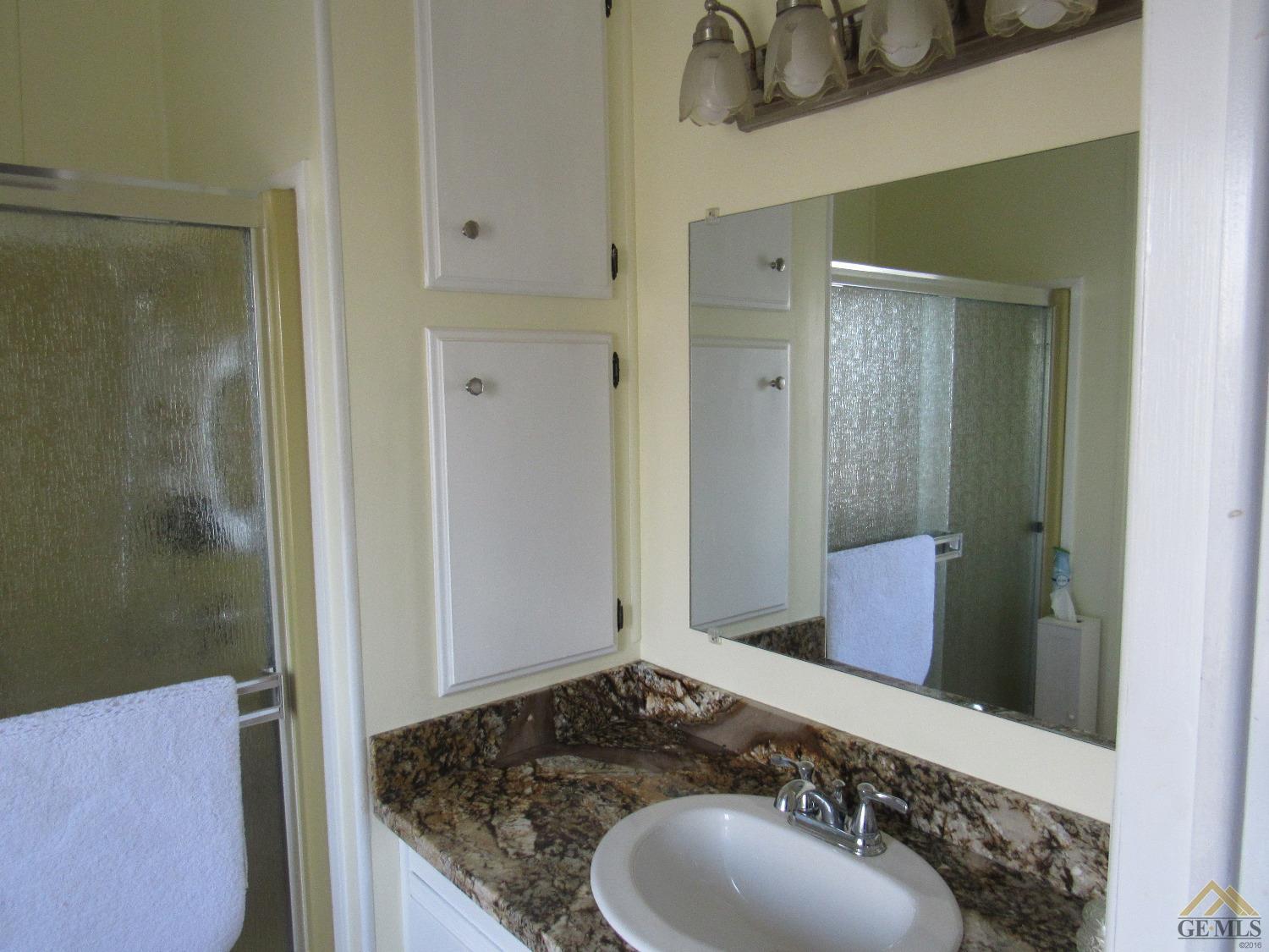 Undisclosed Address Bakersfield, CA 93308 - Photo 13 of 20 a bathroom with a granite countertop sink and a mirror