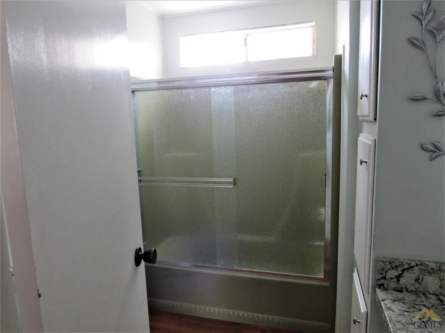 Undisclosed Address Bakersfield, CA 93308 - Photo 18 of 20 a bathroom with a glass shower door