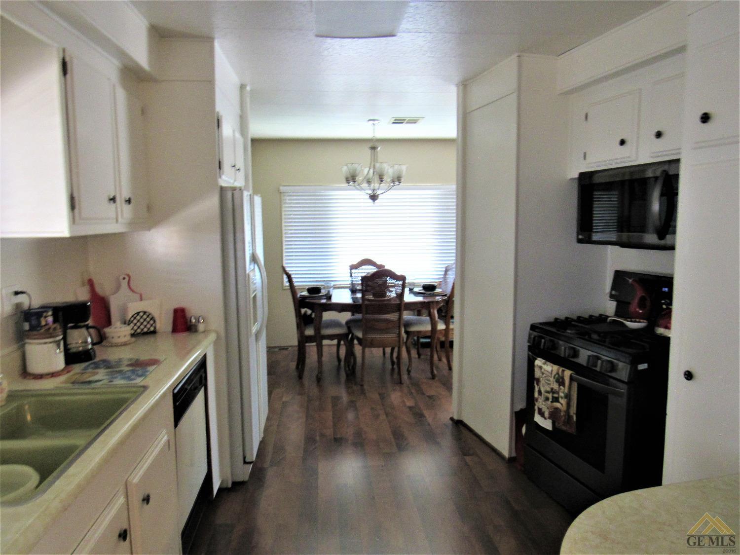 Undisclosed Address Bakersfield, CA 93308 - Photo 9 of 20 a kitchen with a table chairs stove and cabinets
