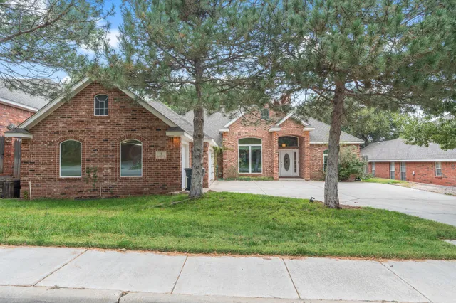 a front view of a house with a garden and yard