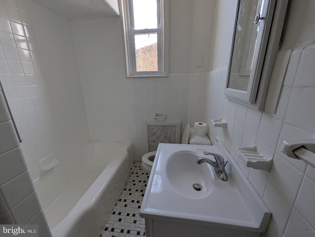 7158 Torresdale Avenue Philadelphia, PA 19135 - Photo 14 of 17 a bathroom with a sink and a mirror