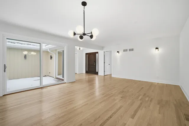 a view of an empty room and window with wooden floor