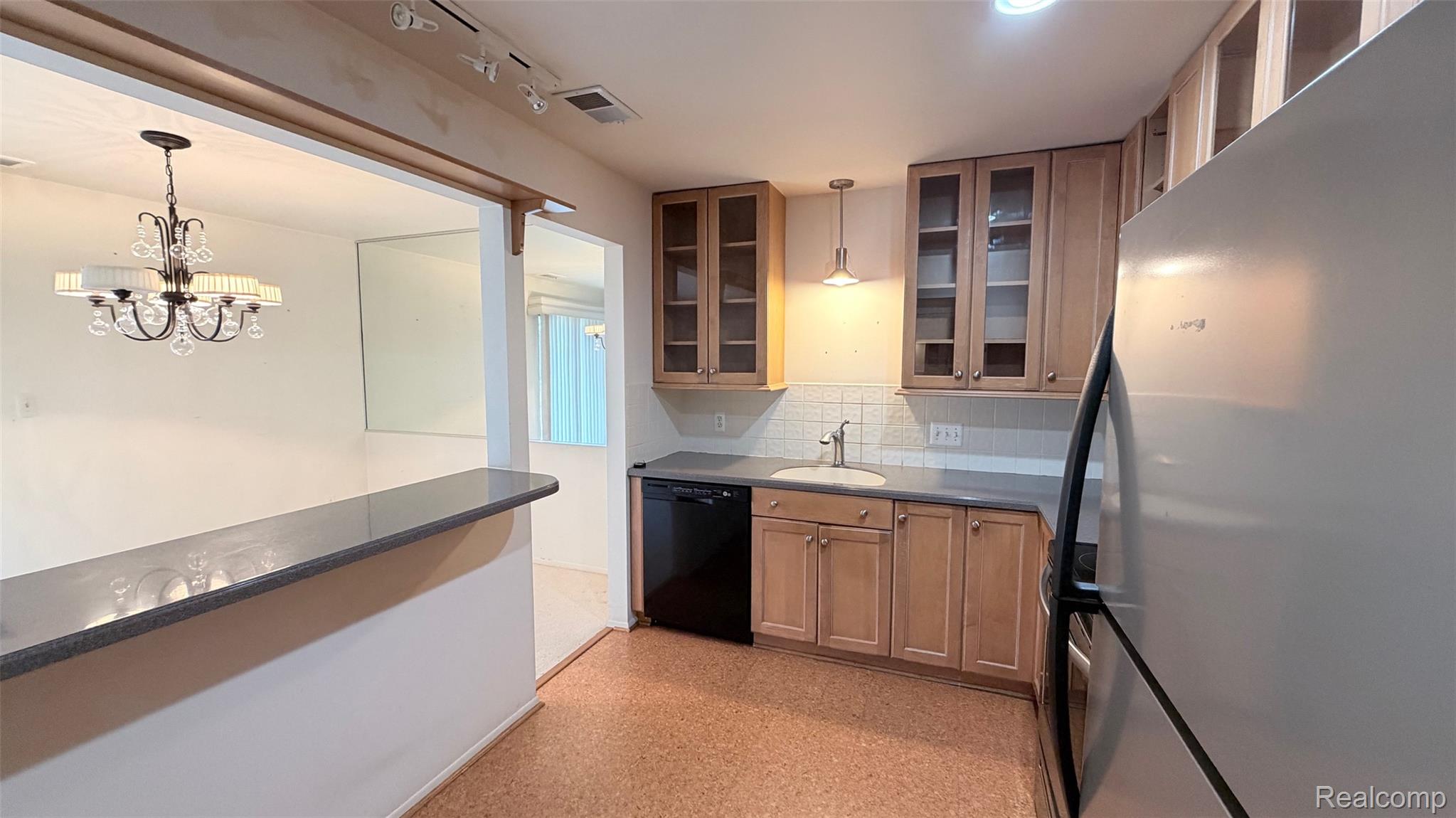 24219 Evergreen Road, Unit 39 Southfield, MI 48075 - Photo 4 of 11 Kitchen featuring freestanding refrigerator, glass insert cabinets, black dishwasher, backsplash, and dark countertops