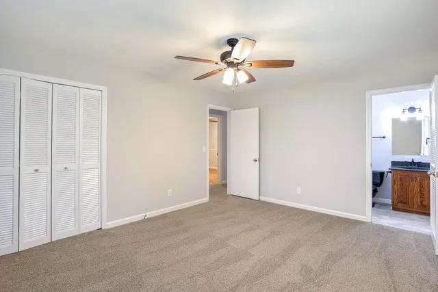 a view of an empty room with a chandelier fan