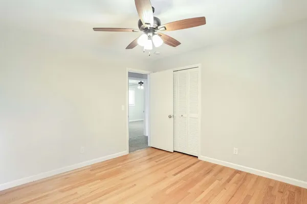 a view of an empty room with wooden floor
