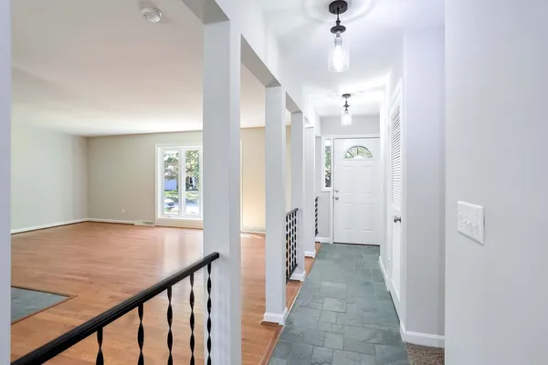 a view of a hallway with a dining table and chairs