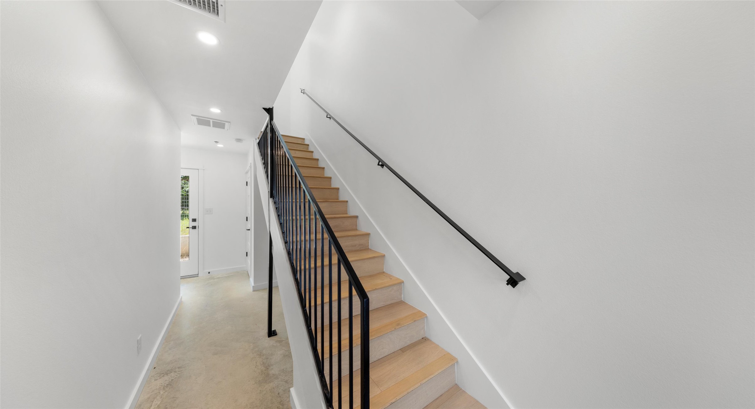 5912 Harold Court, Unit 107 Austin, TX 78721 - Photo 4 of 35 A bright third-level landing with a sleek metal railing — a light, airy connector between the home's living spaces. Model No. 105 Shown.