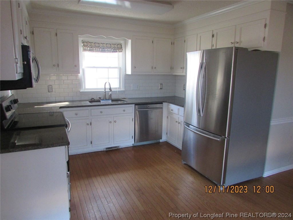 8850 Timothy Road Dunn, NC 28334 - Photo 13 of 15 a kitchen with a refrigerator sink and cabinets