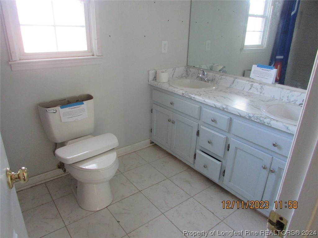 8850 Timothy Road Dunn, NC 28334 - Photo 7 of 15 a bathroom with a granite countertop toilet and sink