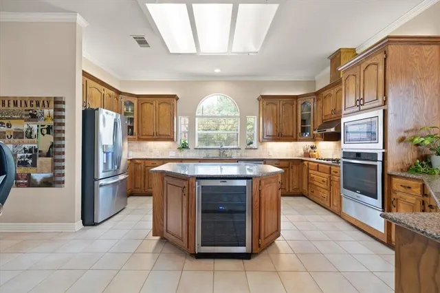 a kitchen with stainless steel appliances granite countertop a stove refrigerator and cabinets