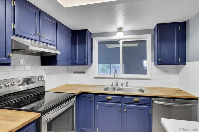 a kitchen with granite countertop a sink stainless steel appliances and cabinets