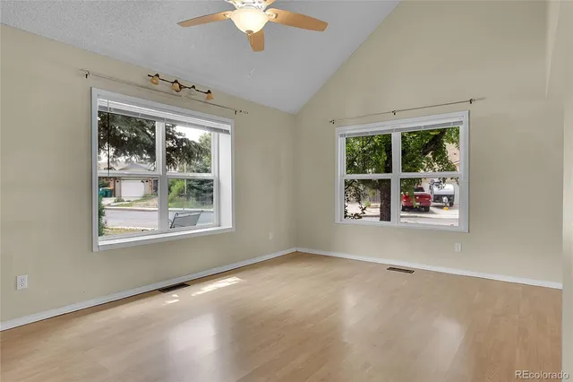 an empty room with windows chandelier windows and chandelier fan