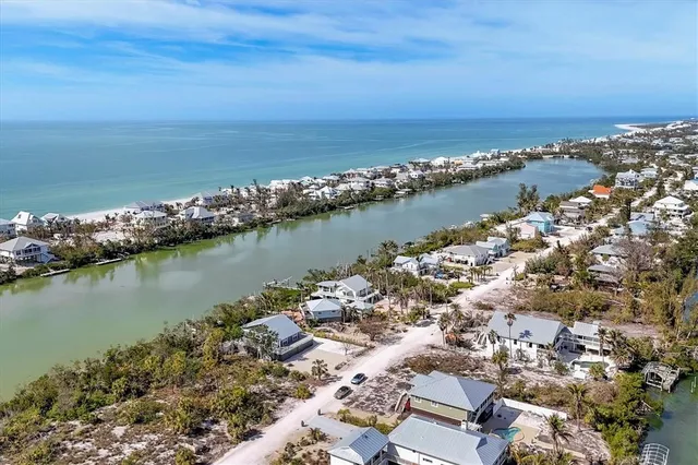 an aerial view of ocean and residential houses with outdoor space